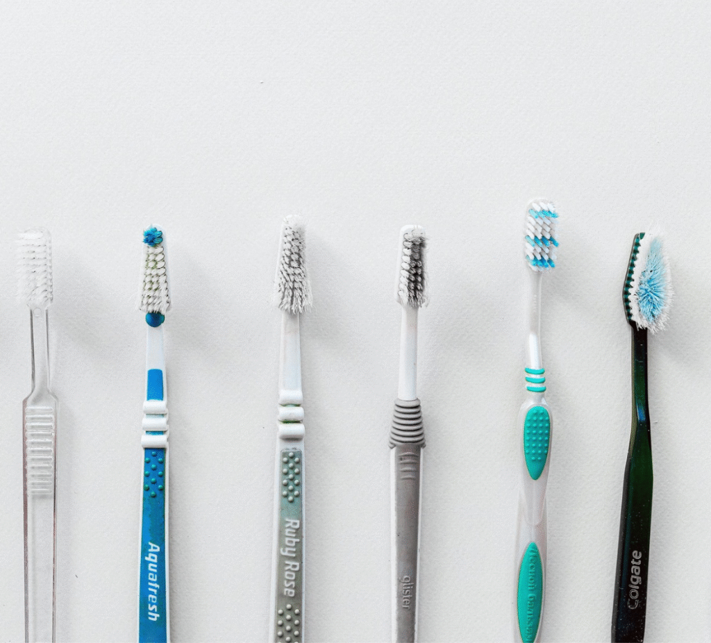 A set of six toothbrushes in front of a white background.