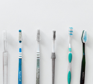A set of six toothbrushes in front of a white background.