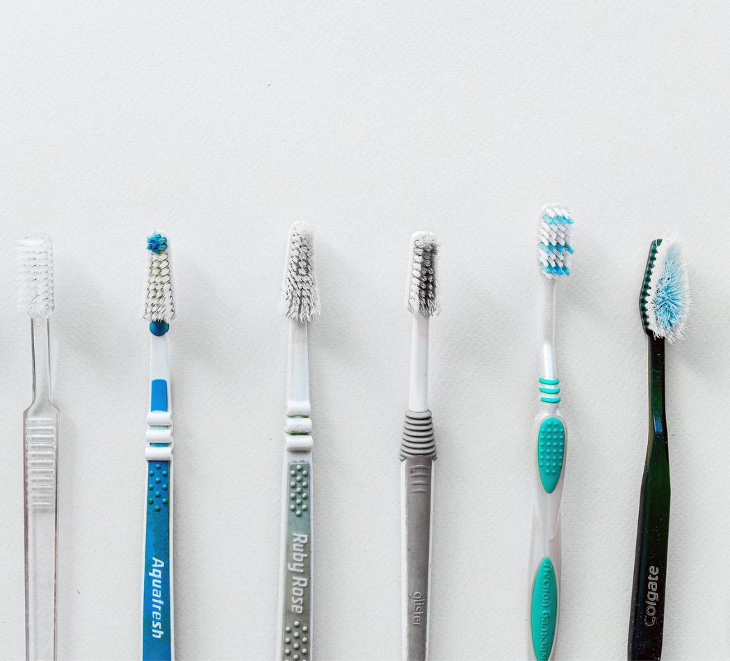 A set of six toothbrushes in front of a white background.