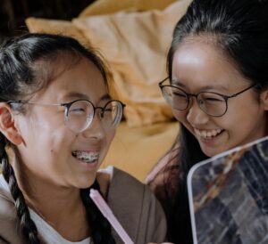 Young people with glasses and braces using a computer.